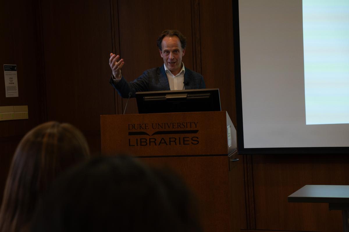 Hein de Haas talking and standing behind a lectern.